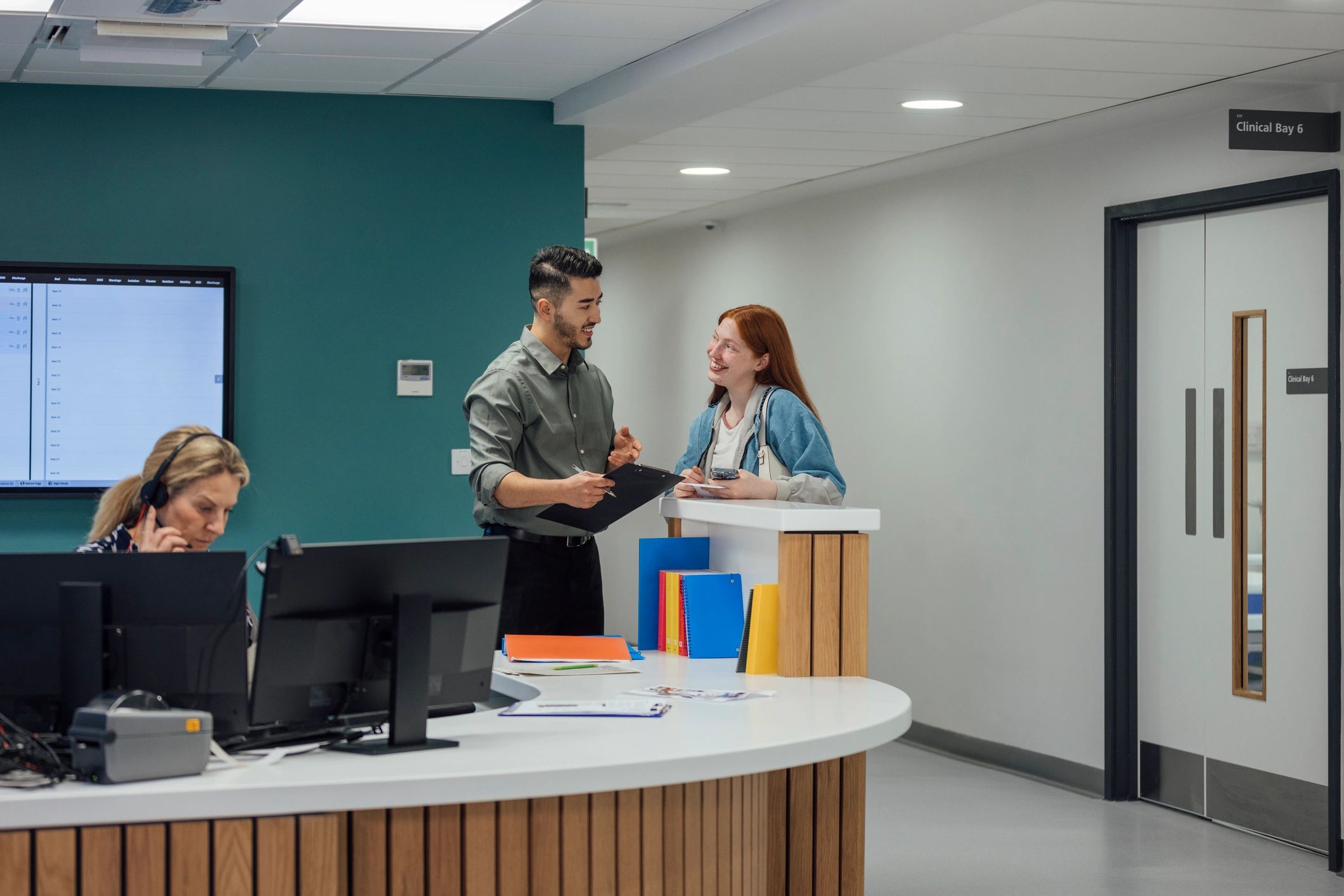 Medical professional assisting a patient at a healthcare facility reception desk